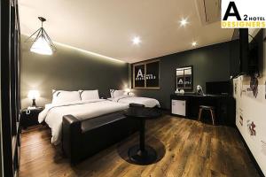 um quarto com uma cama grande e uma mesa em A2 Hotel Desingers em Yesan