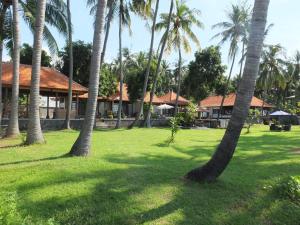 a group of palm trees in front of a building at The Amrita - Salt Farm Villas in Tejakula