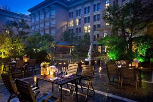 a patio with tables and chairs in front of a building at Greenland Yuhao Hot Spring Hotel in Jiangning