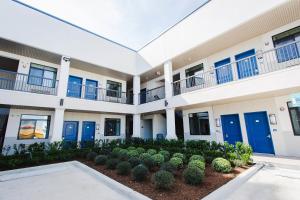 un edificio de apartamentos con puertas azules y un patio en Palace Inn Blue US-59 & Gessner en Houston