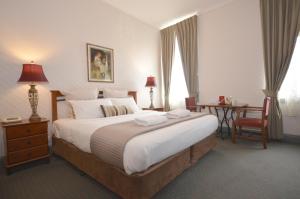 a hotel room with a large bed and a desk at Central Springs Inn in Daylesford