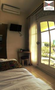 Un dormitorio con una cama y una puerta corrediza de vidrio. en The Alley City Hotel, en Sanur