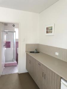 a bathroom with a sink and a shower at Thirroul Beach Motel in Wollongong