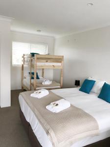 two beds in a bedroom with blue and white at Thirroul Beach Motel in Wollongong