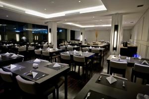 a restaurant with tables and chairs in a room at Samala Hotel Jakarta Cengkareng in Jakarta