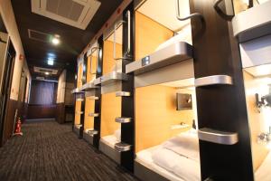 a row of bunk beds on a train at Sejour Inn Capsule in Hiroshima