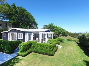 a house with a large hedge in front of a garden at Manea Villa in Palm Beach