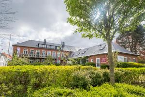 un edificio con un árbol en el primer plano en BE BIO Hotel be active en Tönning
