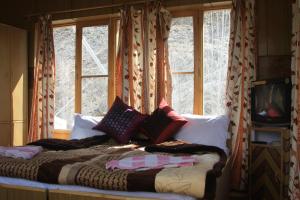 a bed sitting in a room with a window at New Moon Guest House in Leh