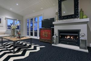 a living room with a fireplace and a tv at Manea Villa in Palm Beach