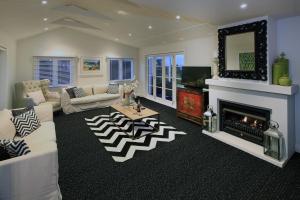 a living room with a couch and a fireplace at Manea Villa in Palm Beach