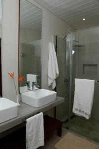 a bathroom with two sinks and a glass shower at Les 2 canons in Flic-en-Flac