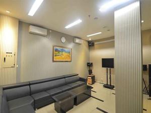 a waiting room with a couch and a tv at World Hotel Jakarta - Bandengan in Jakarta