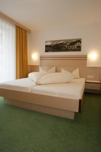 ein Schlafzimmer mit einem großen Bett in einem Zimmer in der Unterkunft Haus Mühlbach in Fiss