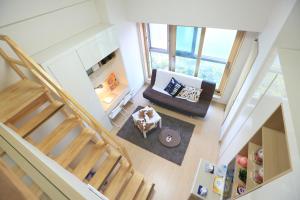 
a living room filled with furniture and a staircase at Lotte World Lake View Loft in Seoul
