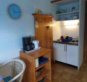a small kitchen with a sink and a clock on the wall at Landhaus Steinbrech in Grainau