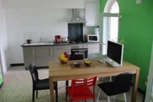 - une cuisine avec une table en bois et un ordinateur dans l'établissement Villa Normande, au Tréport