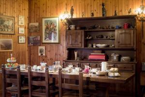 a dining room with a wooden table and chairs at B&B Gennarcu in Ussàssai
