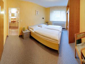 a bedroom with a large bed and a bathroom at Hotel Keinath Stuttgart in Stuttgart