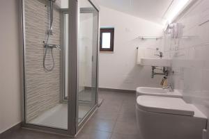 a bathroom with a shower and a toilet and a sink at La Chambre in Paola