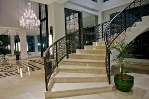 a staircase in a lobby with a chandelier at Samala Hotel Jakarta Cengkareng in Jakarta