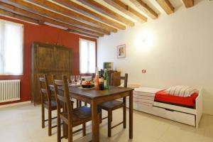 a dining room with a table and chairs and a bed at Salizada San Francesco in Venice