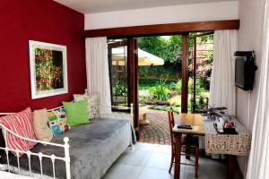 een woonkamer met een bed en een tafel en een tafel bij Oliveroom Self Catering and B&B in Durban