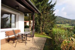 a table and chairs on a patio with a view at Feriendorf am Hundsrück in Floh