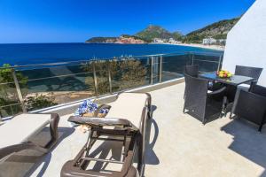 een balkon met een tafel en stoelen en de oceaan bij Apartmani Capri in Sutomore