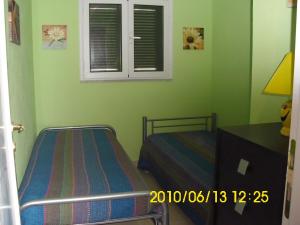 サンタ・テレーザ・ガッルーラにあるCasa Carrubaのベッドルーム1室(ベッド2台、テーブル、窓付)