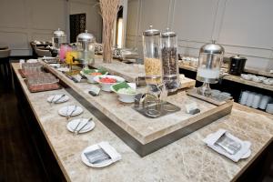 a buffet line with plates and bowls of food at Samala Hotel Jakarta Cengkareng in Jakarta