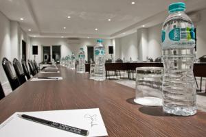 a long table with bottles of water and a pen at Samala Hotel Jakarta Cengkareng in Jakarta