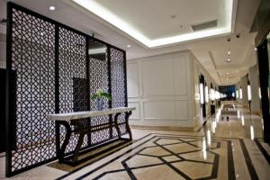a lobby with a bench and a wall of windows at Samala Hotel Jakarta Cengkareng in Jakarta