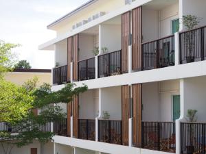 an apartment building with balconies and trees at Crystal Lamai Hotel in Lamai