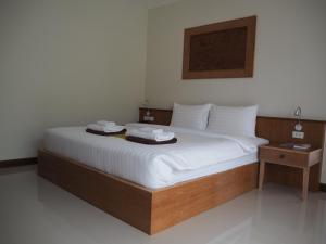 a bedroom with a bed with white sheets and two tables at Crystal Lamai Hotel in Lamai