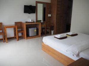 a bedroom with a bed and a desk and a television at Crystal Lamai Hotel in Lamai