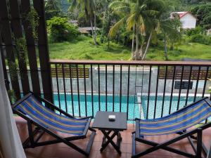 two chairs on a balcony with a swimming pool at Crystal Lamai Hotel in Lamai
