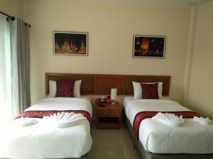 A bed or beds in a room at Lampang Green Garden Resort