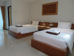 a bedroom with two beds with white sheets at Crystal Lamai Hotel in Lamai