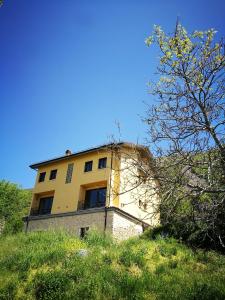 ein gelbes Gebäude auf einem Hügel in der Unterkunft Bacca Blu in Villa Santa Lucia degli Abruzzi