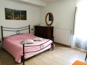 ein Schlafzimmer mit einem rosa Bett und einem Spiegel in der Unterkunft Bacca Blu in Villa Santa Lucia degli Abruzzi