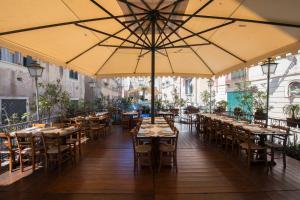 ein Restaurant mit Tischen und Stühlen und einem großen Sonnenschirm in der Unterkunft Camere da Cecè in Tropea