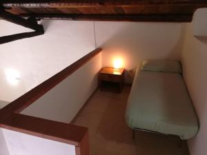 カステッランマーレ・デル・ゴルフォにあるCasa Molinelloのベッド1台、テーブルの上にランプが備わる小さな客室です。
