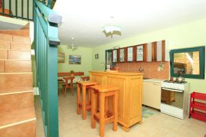 a kitchen with wooden cabinets and a table and chairs at Stone House Oreb`s Cottage in Vela Luka