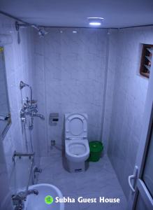 a small bathroom with a toilet and a sink at Subha Guest House in Bhaktapur