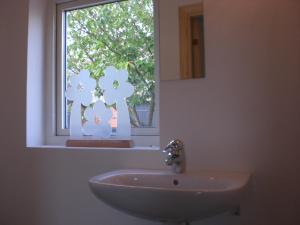 a bathroom with a sink and a window at Ola-Nils Gård in Borrby
