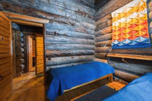 um quarto com uma cama num chalé de madeira em Pikku-Junga em Kuusamo