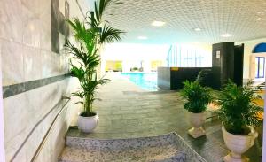 a lobby with potted plants and a swimming pool at Hotel Terme Eden in Abano Terme