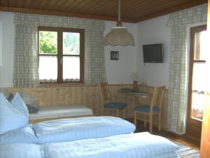 1 dormitorio con cama, mesa y TV en Biobauernhof Windbachgut, en Eben im Pongau