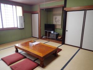a living room with a coffee table and a television at Seisenso in Nozawa Onsen